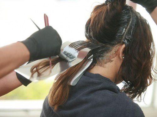 Após aplicar a tinta em toda a raiz e antes mesmo de ela agir, o cabeleireiro já faz as luzes com papel para clarear em três tons o meu cabelo.